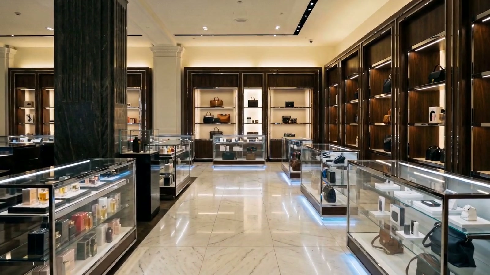 Lit glass display cases in a goods hall, each holding small objects, reflected in a polished floor.